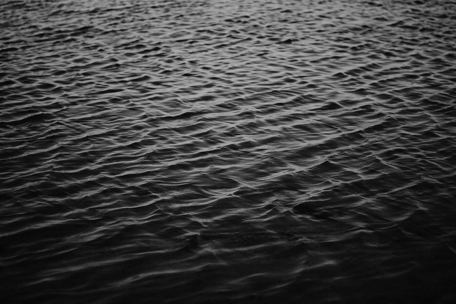 Dark, moving water surface at night.